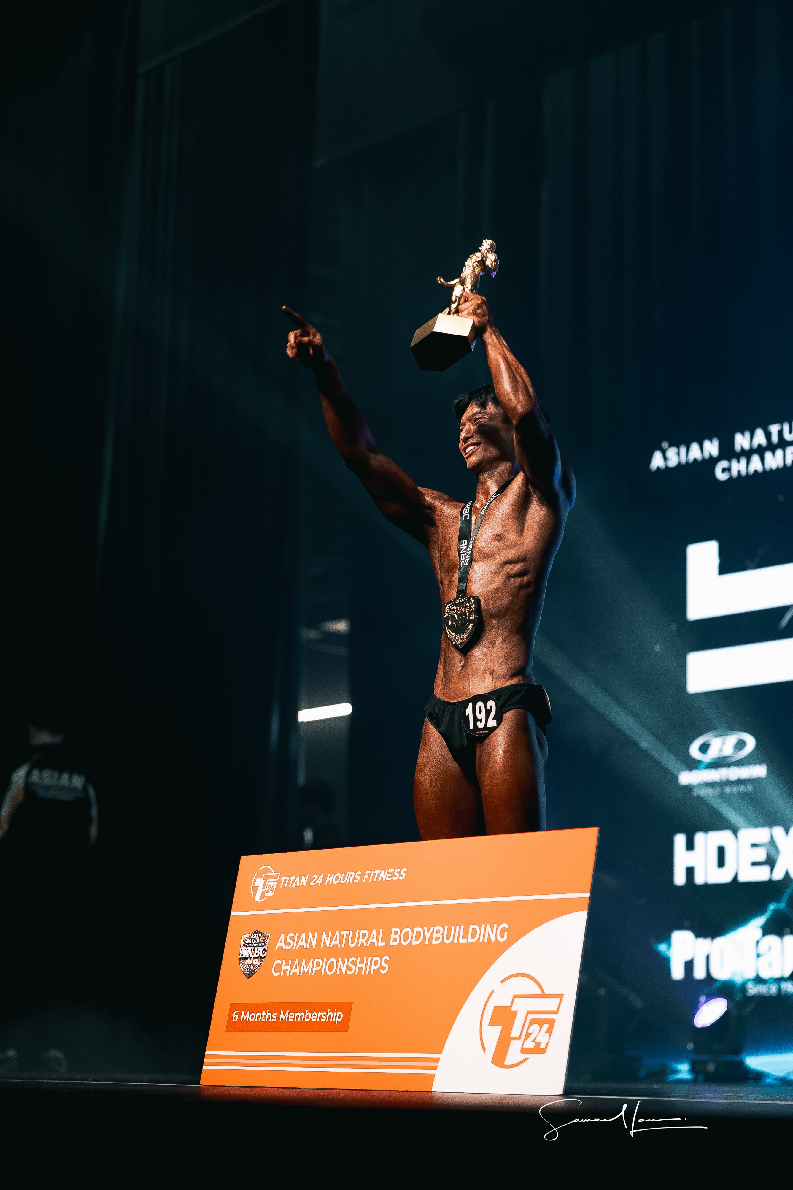 Vincent raising the ANBC junior Classic Physique trophy on stage